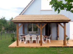 Pergola avec structure bois et couverture en paillasson de roseaux de Camargue. Réalisée avec 6 rouleaux de 2m X 5m.